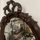 Antique oval mirror in carved wood and Louis XVI style knot