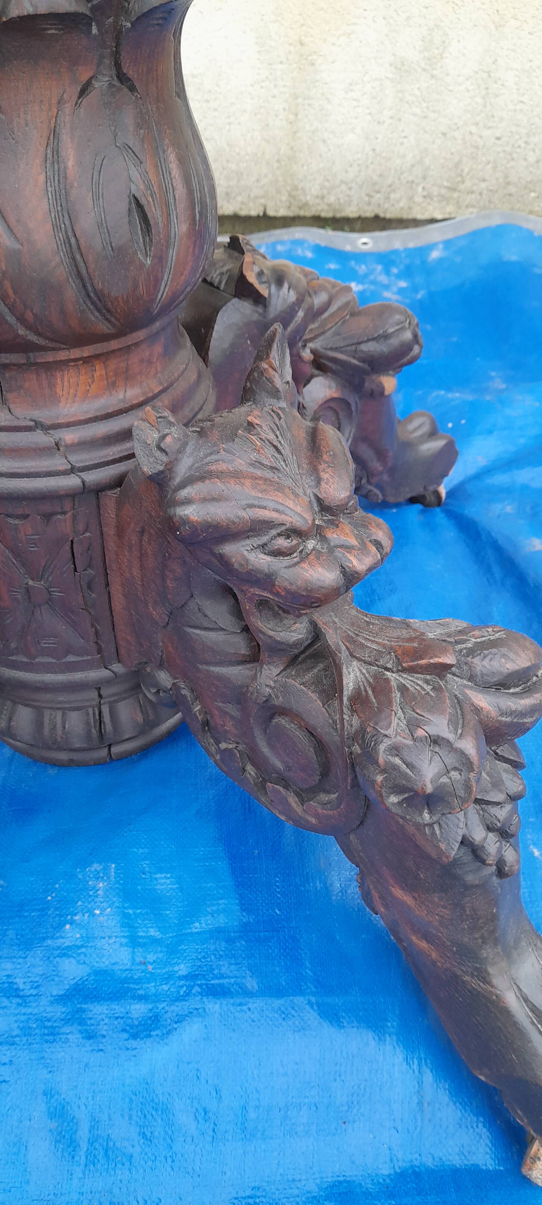 Round table in molded and carved oak with quill decoration, central shaft with 4 runners