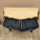 Curved commode painted in black and wood.