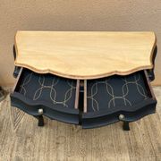Commode galbée peinte en noir et bois