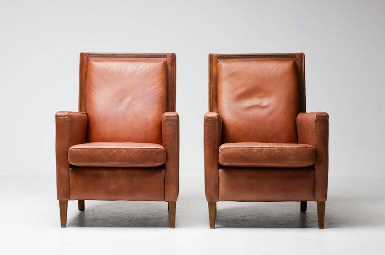Pair of Art Deco armchairs in brown leather and teak, Netherlands, 1970s.