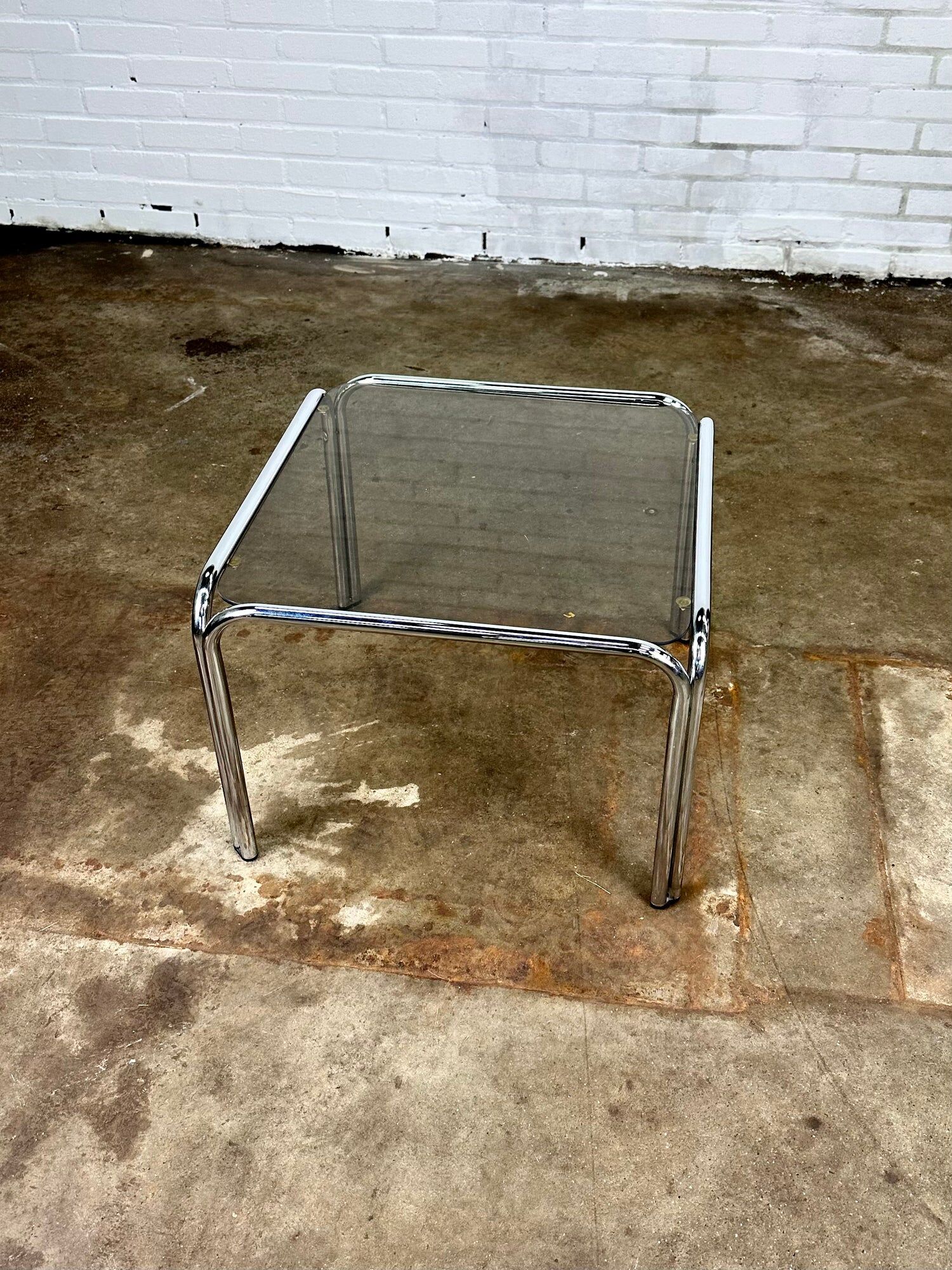 Table basse vintage en métal chromé et verre fumé