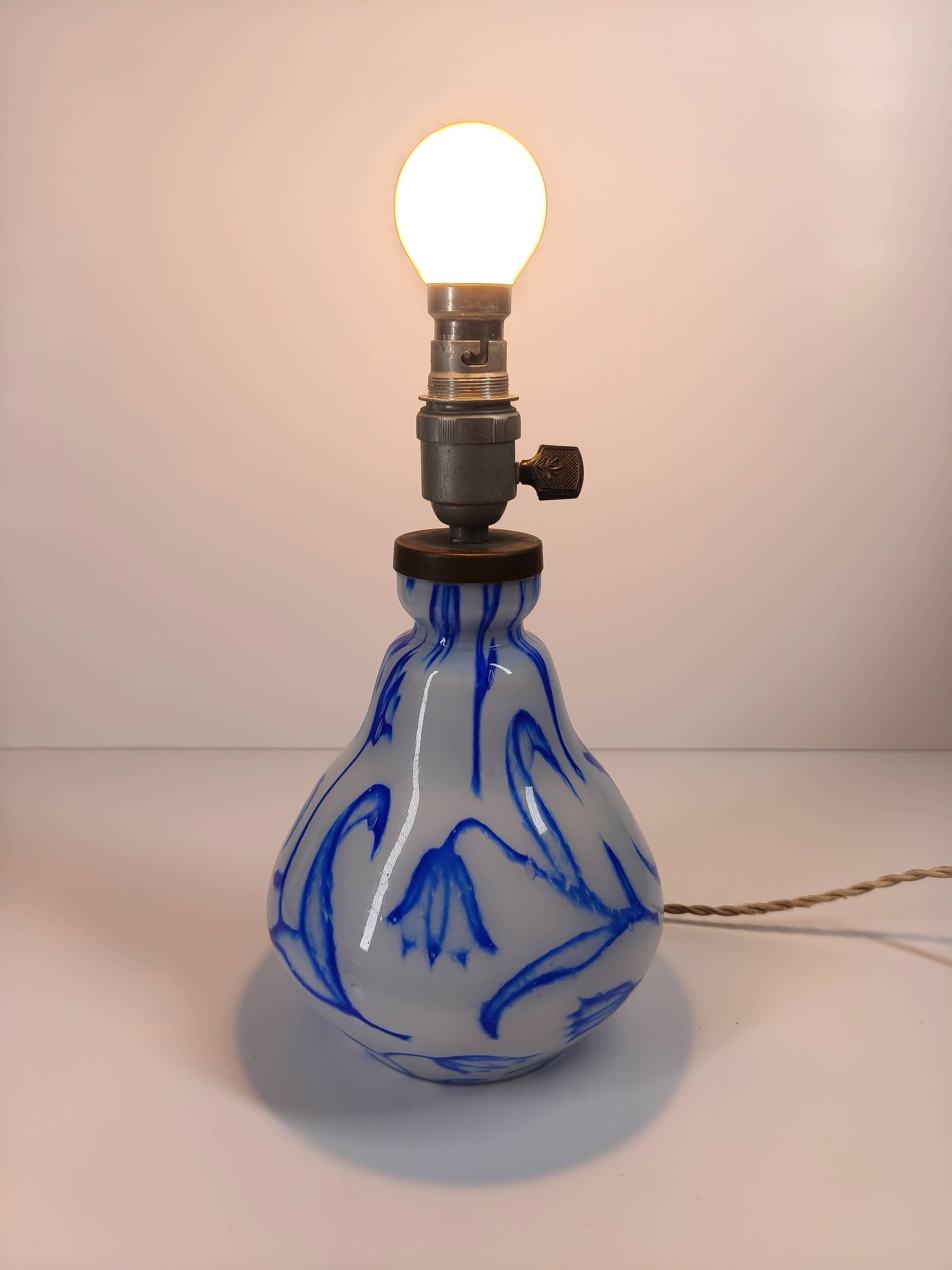 Antique table lamp in opaline glass with blue floral decoration.