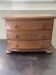 Blonde wooden doll's chest with brass handles.