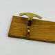 Vintage wall coat rack in brass and wood design.