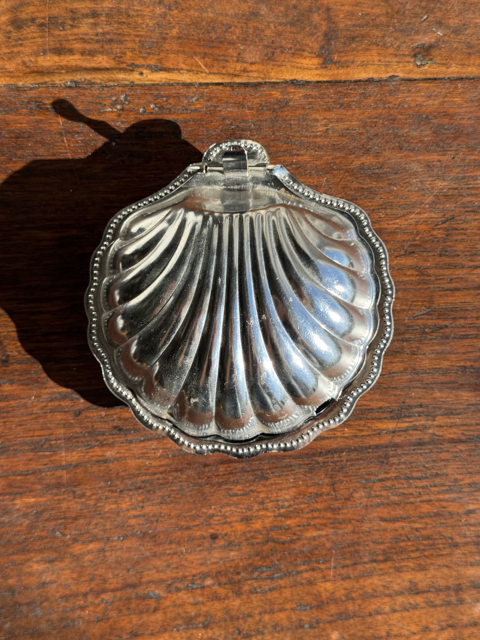 Vintage silver-plated shell butter dish with blue bowl.