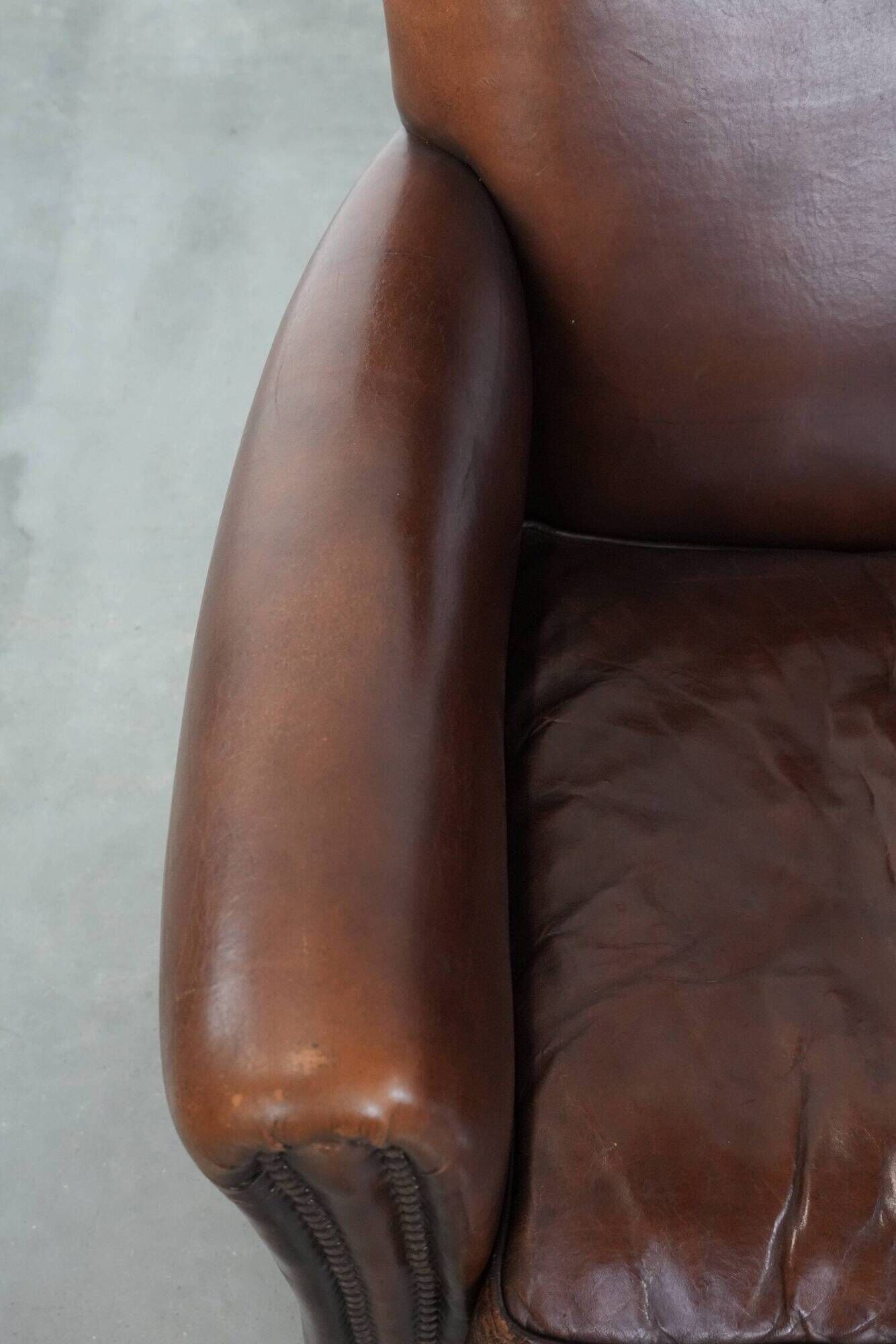 Ensemble de deux fauteuils en cuir de mouton vintage au caractère marqué.