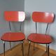 Chairs in red-orange formica and chrome metal.
