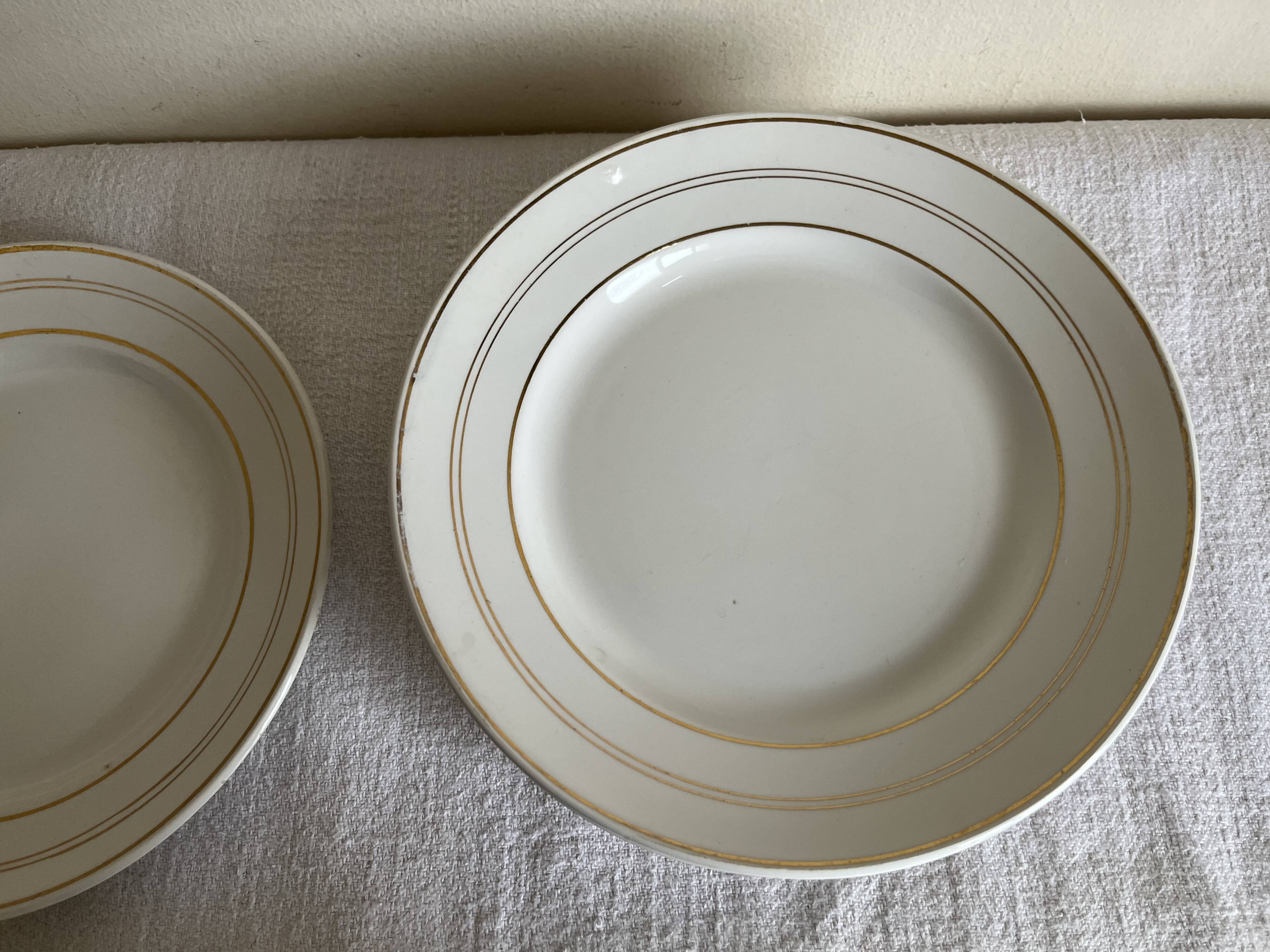 Set of 8 modernist flat plates in fine earthenware with pure gold trim, 1930.