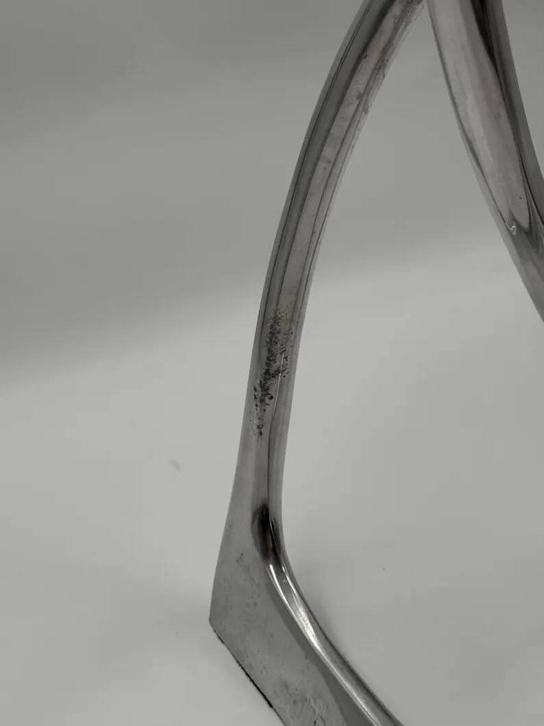 Chromed sculptural art object, abstract modernist shape in metal, contemporary design accent, brutalist interior decoration.