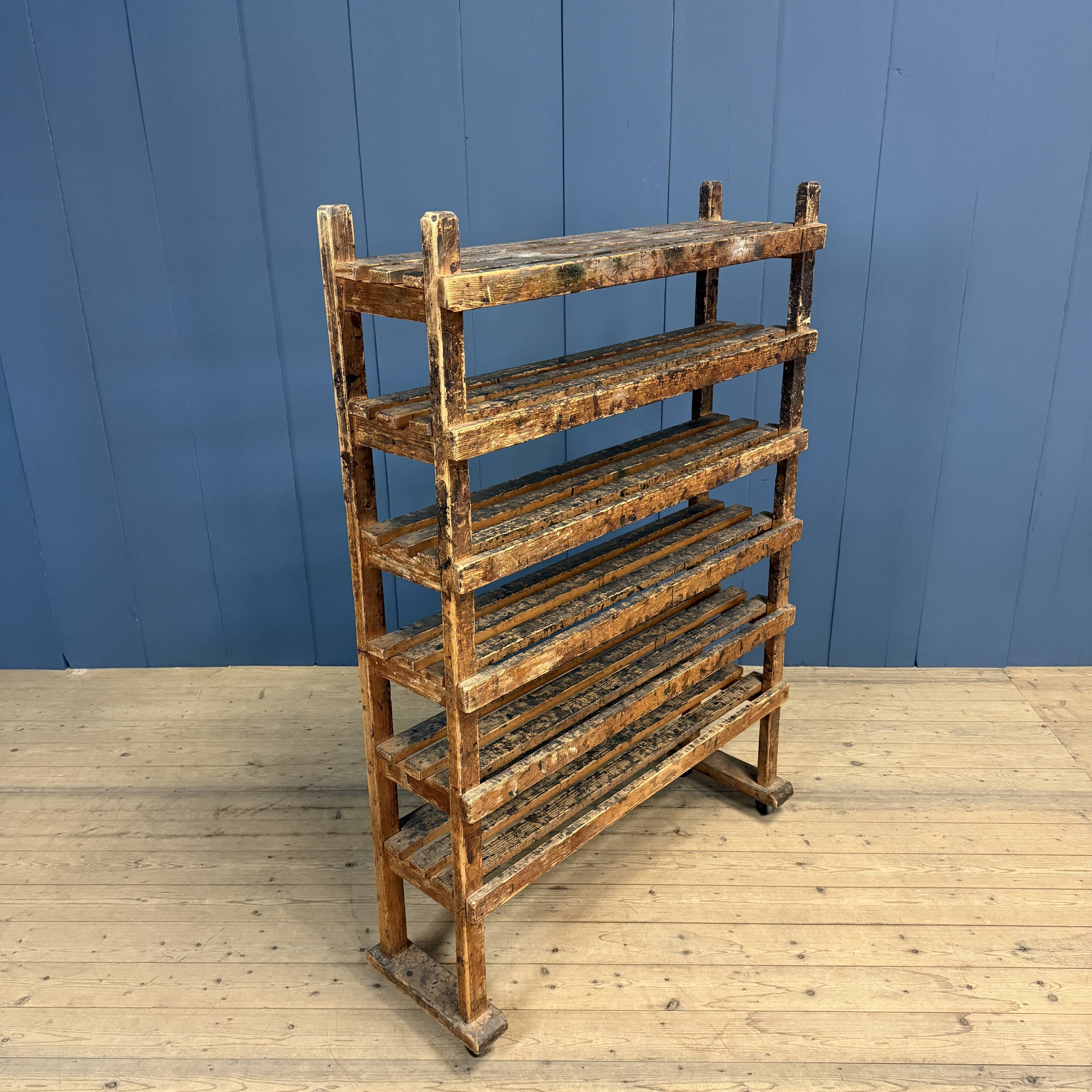 Old wooden workshop shelf with cast iron wheels.