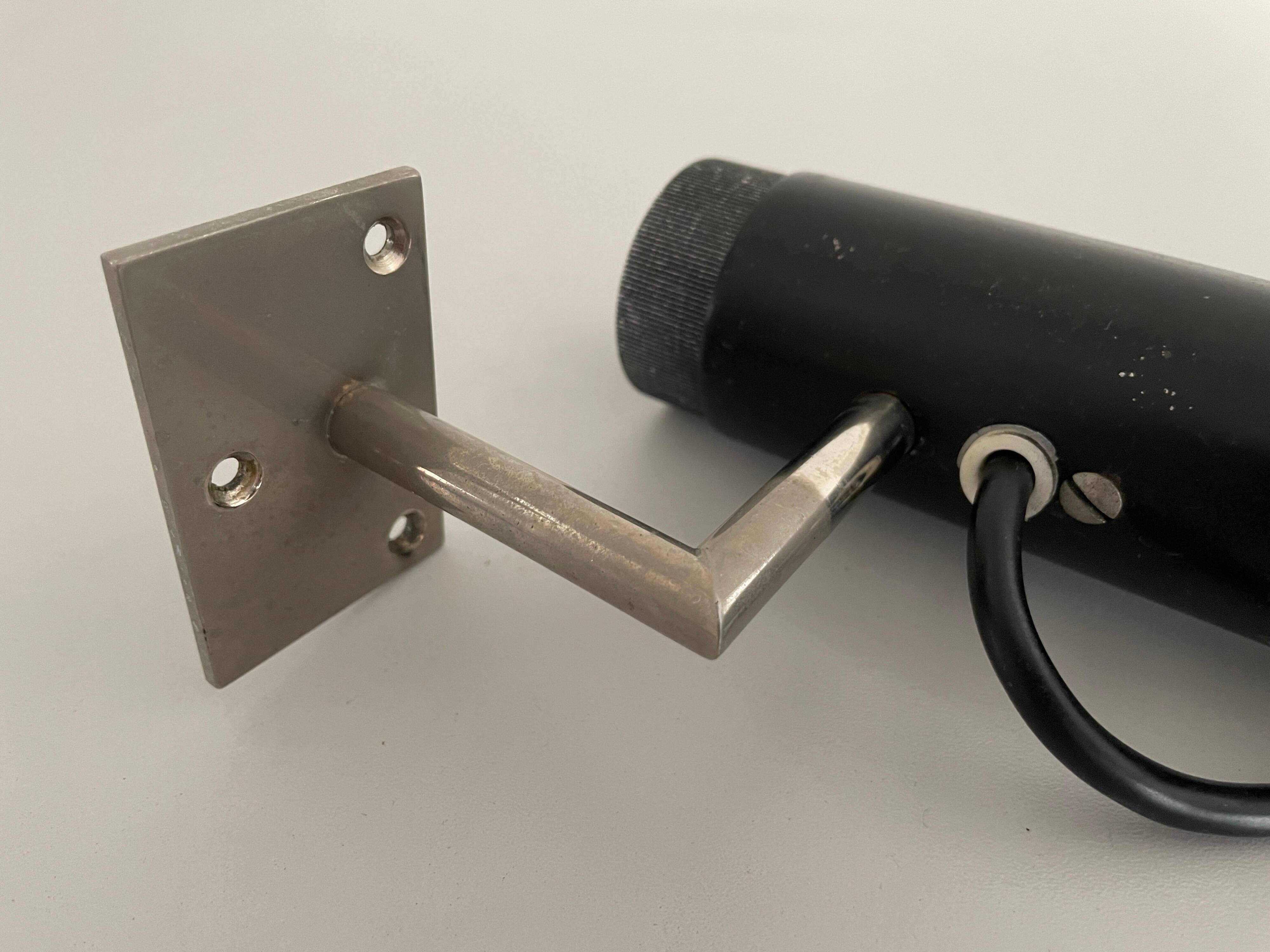 Minimalist black metal wall light with a cylindrical design, 1960s, Germany.