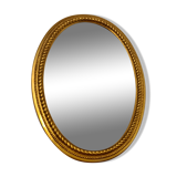 Beveled oval mirror in gilded wood 78×58cm