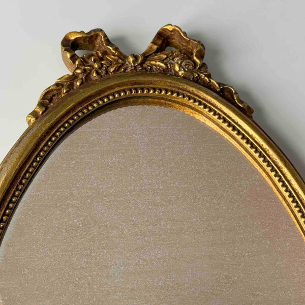 Miroir ovale vintage doré style Louis XVI à décor de rubans et de roses