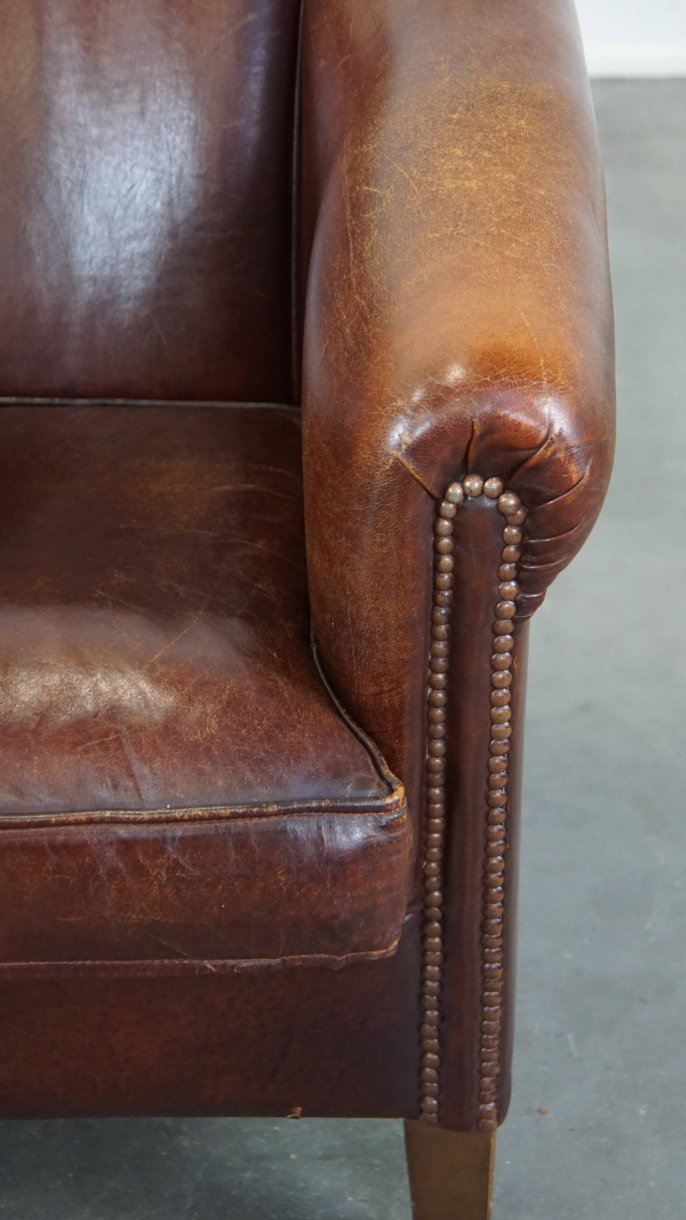 Sheepskin club armchair, correct finishing with decorative nails