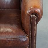 Sheepskin club armchair, correct finishing with decorative nails