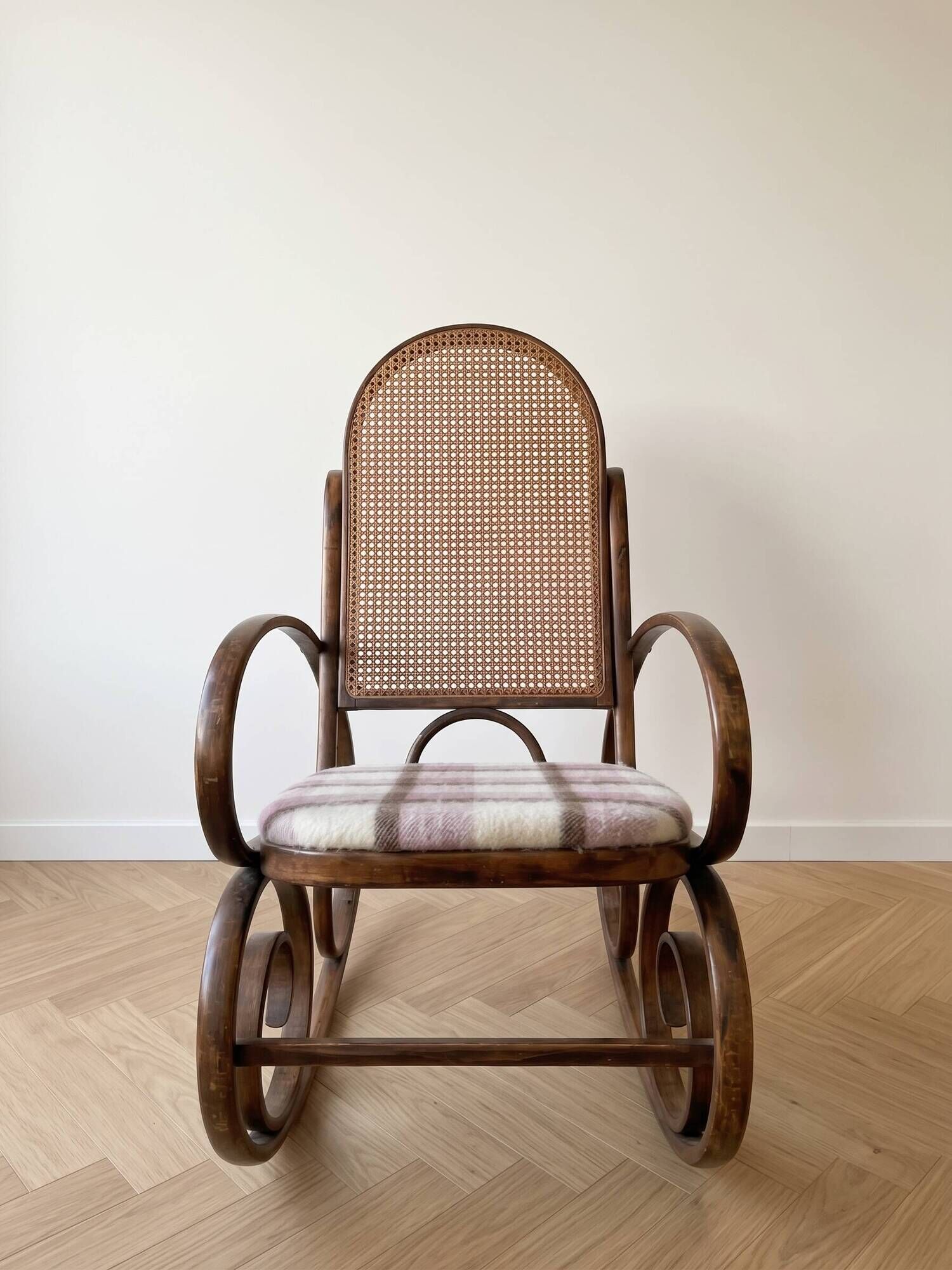 Antique rocking chair in curved wood and caning.