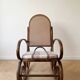 Antique rocking chair in curved wood and caning.
