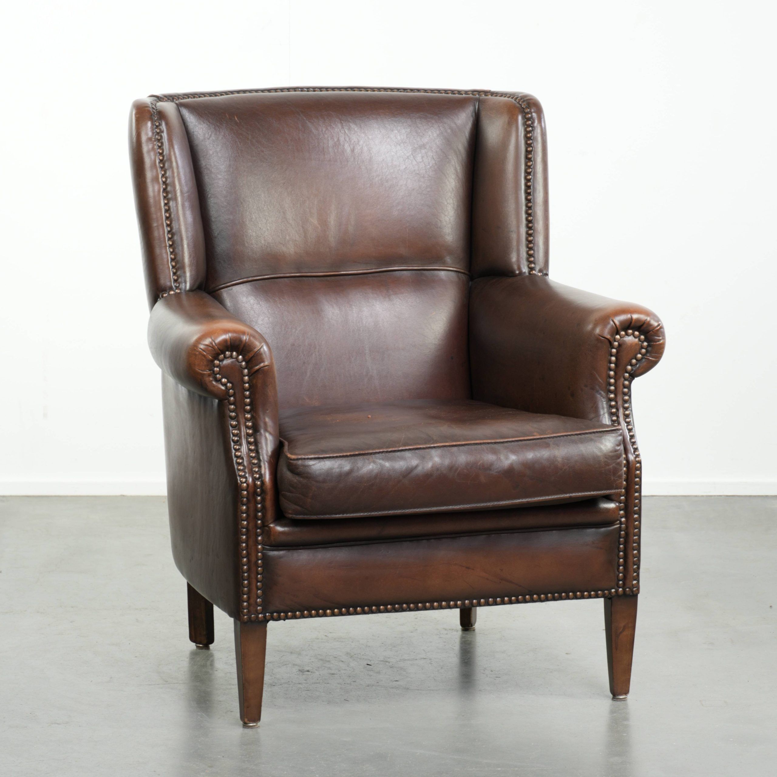 Subtle sheepskin wingback armchair with a deep cognac colour
