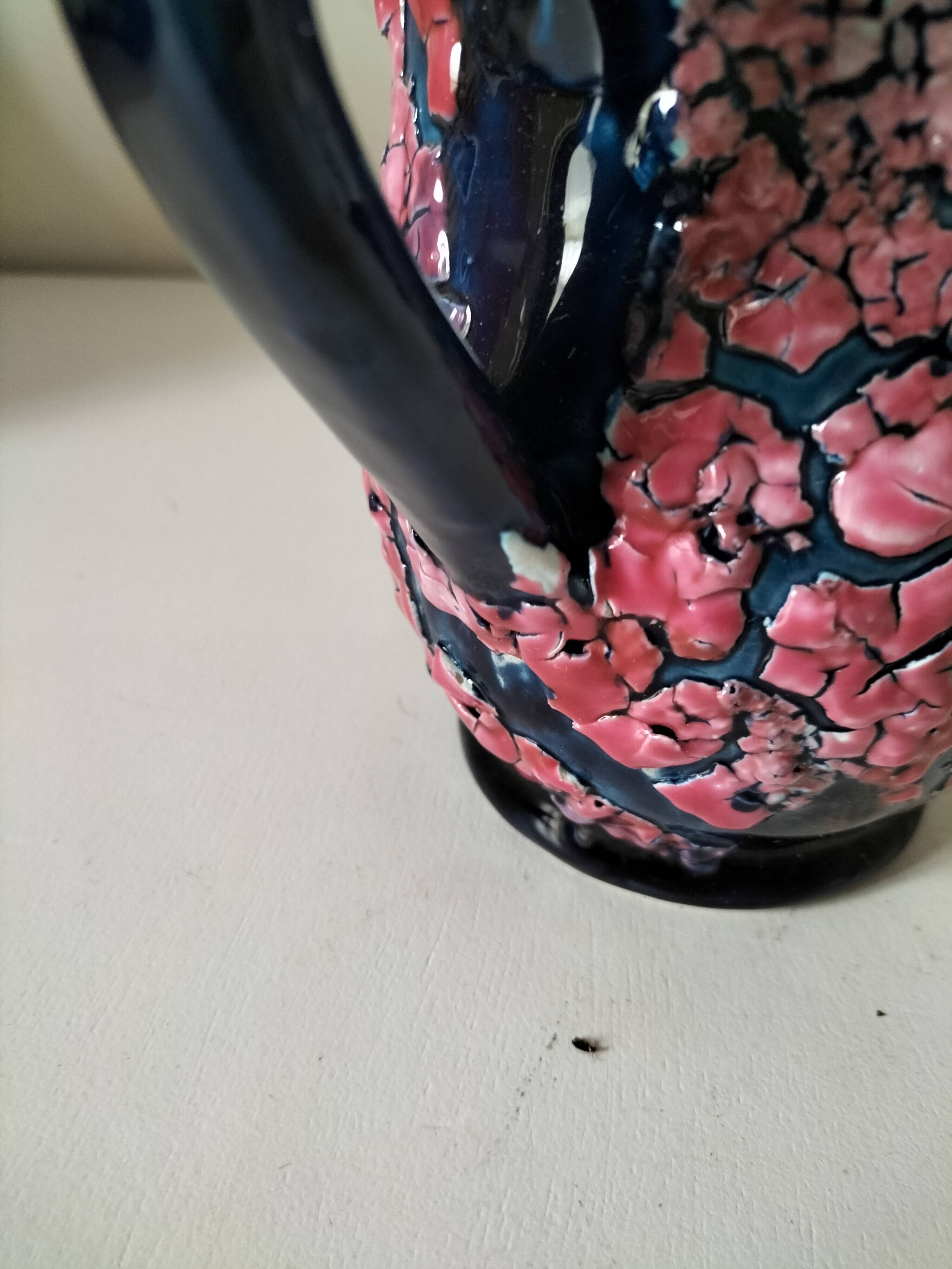 Vintage pitcher in midnight blue glazed ceramic with bright pink relief