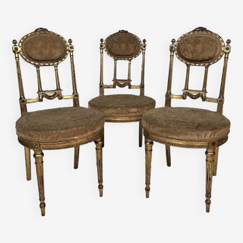 Series of three Louis XVI style chairs in gilded wood, circa 1900