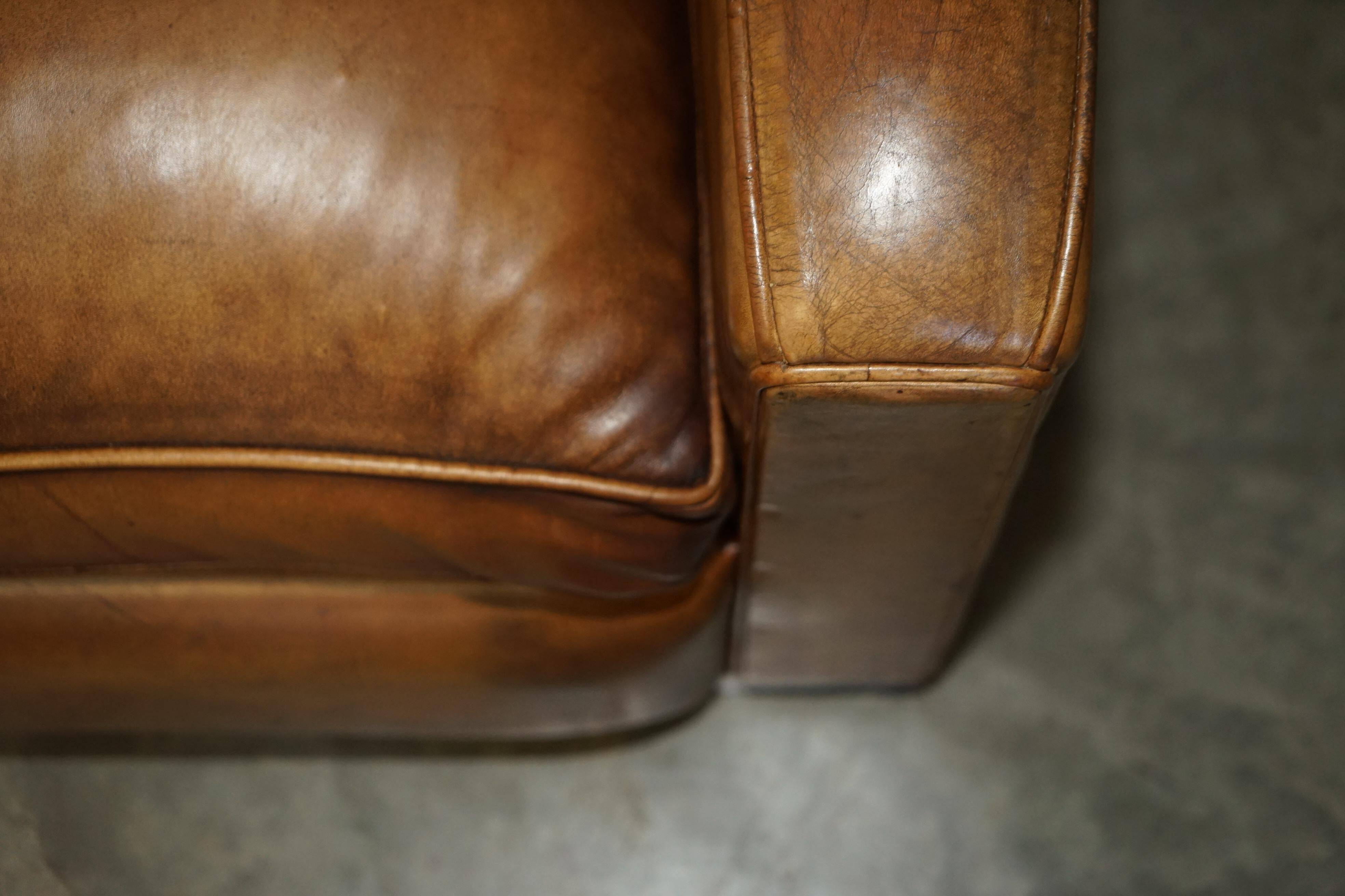 Three-seater Art Deco style leather sofa with feather cushions.
