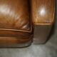 Three-seater Art Deco style leather sofa with feather cushions.