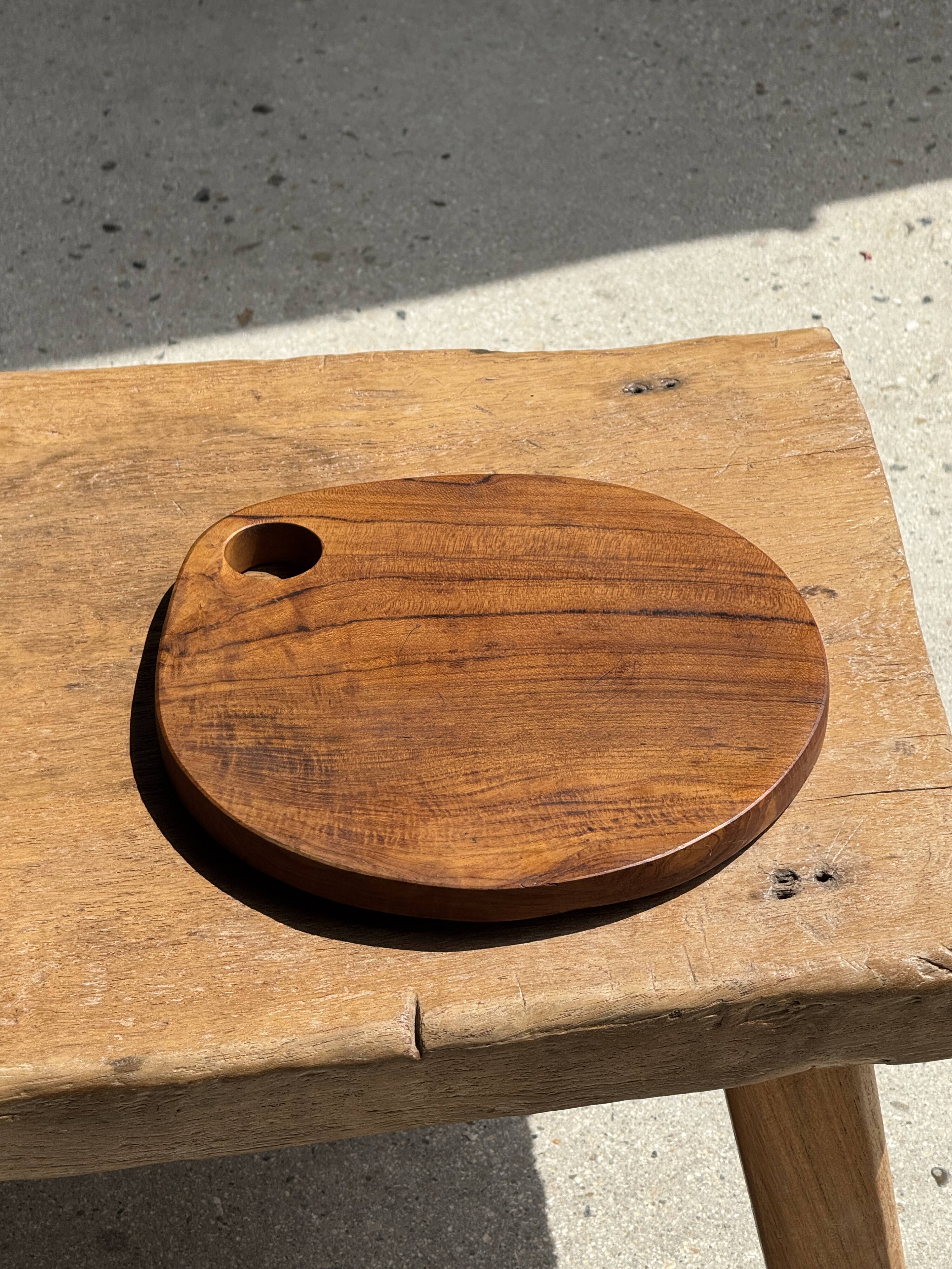 Average circular teak monoxyle chopping board with handle 26 x 18.