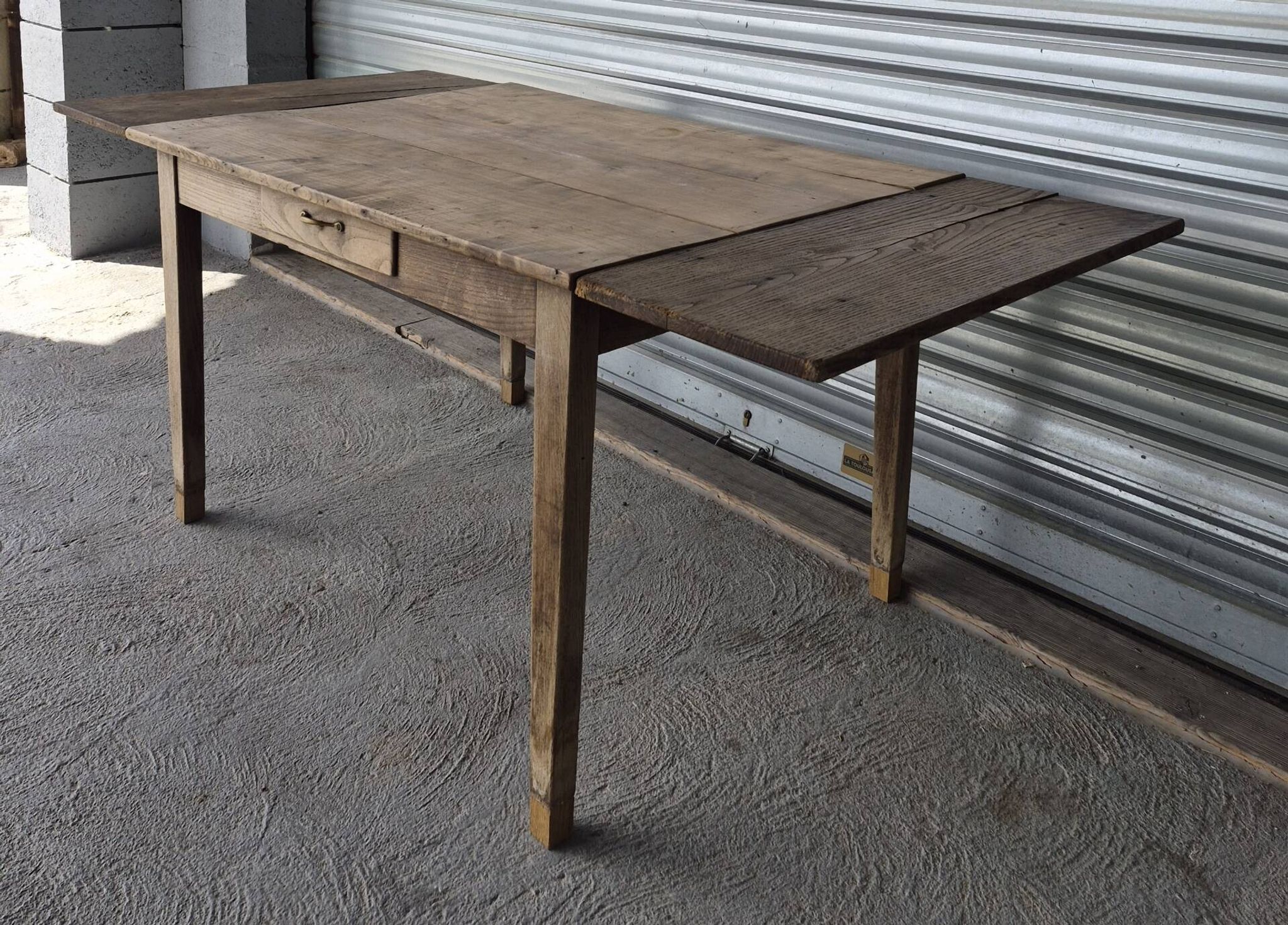 Old farmhouse table with its 2 extensions and raised legs.