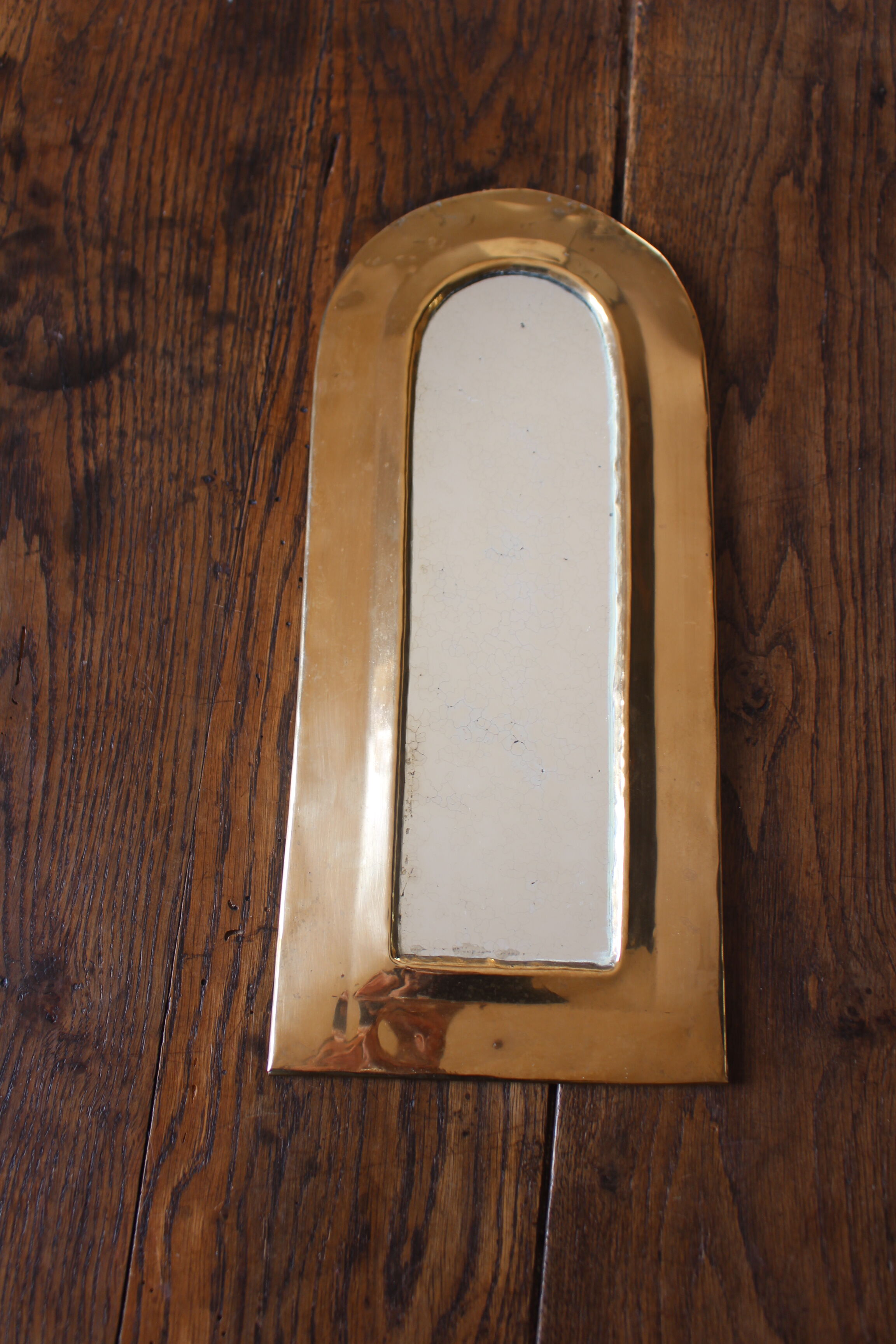 Rounded brass mirror