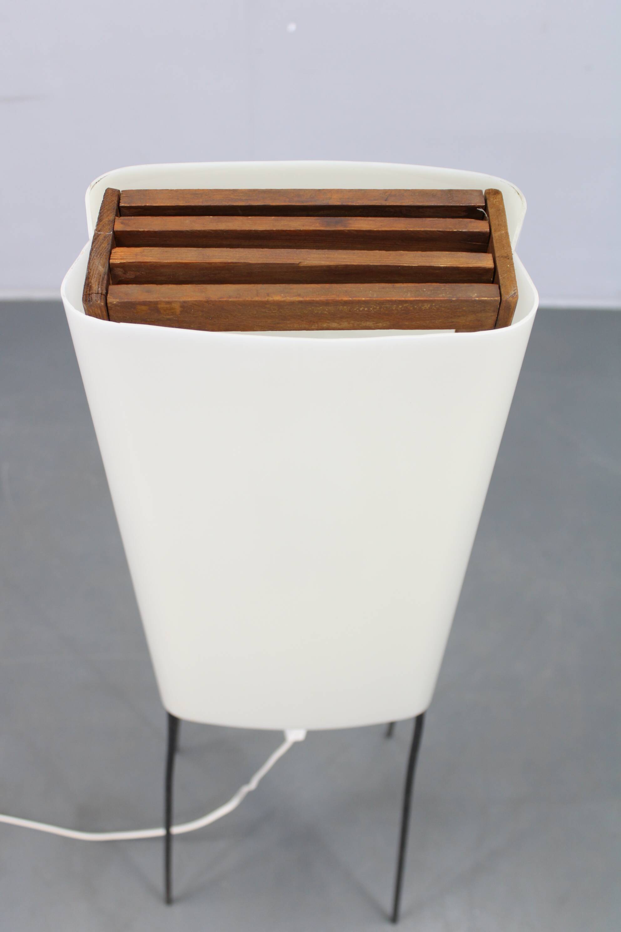 Mid-century modern floor lamp on iron legs with plastic shade and wood accent