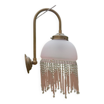 Brass swan neck wall lamp with pink glass globe and Charleston tassels
