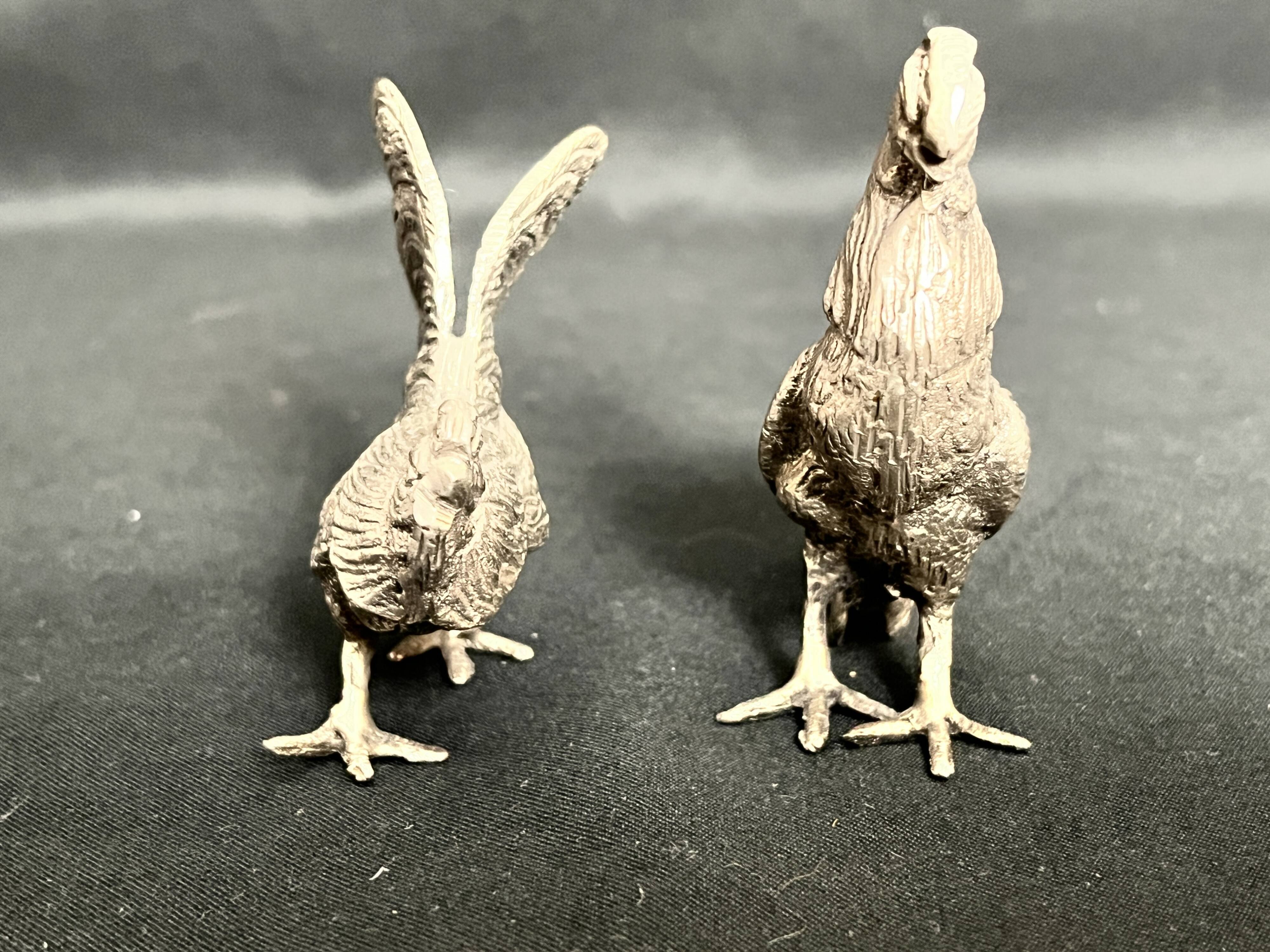 Showcase objects, two 20th century metal rooster and hen subjects