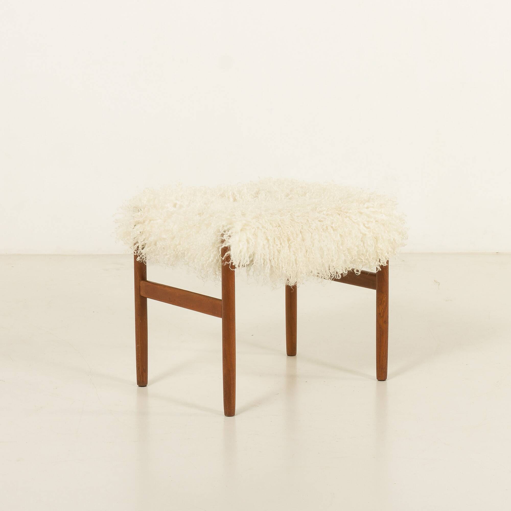 Pouf en teck danois des années 60 recouvert de peau de mouton à poils longs.