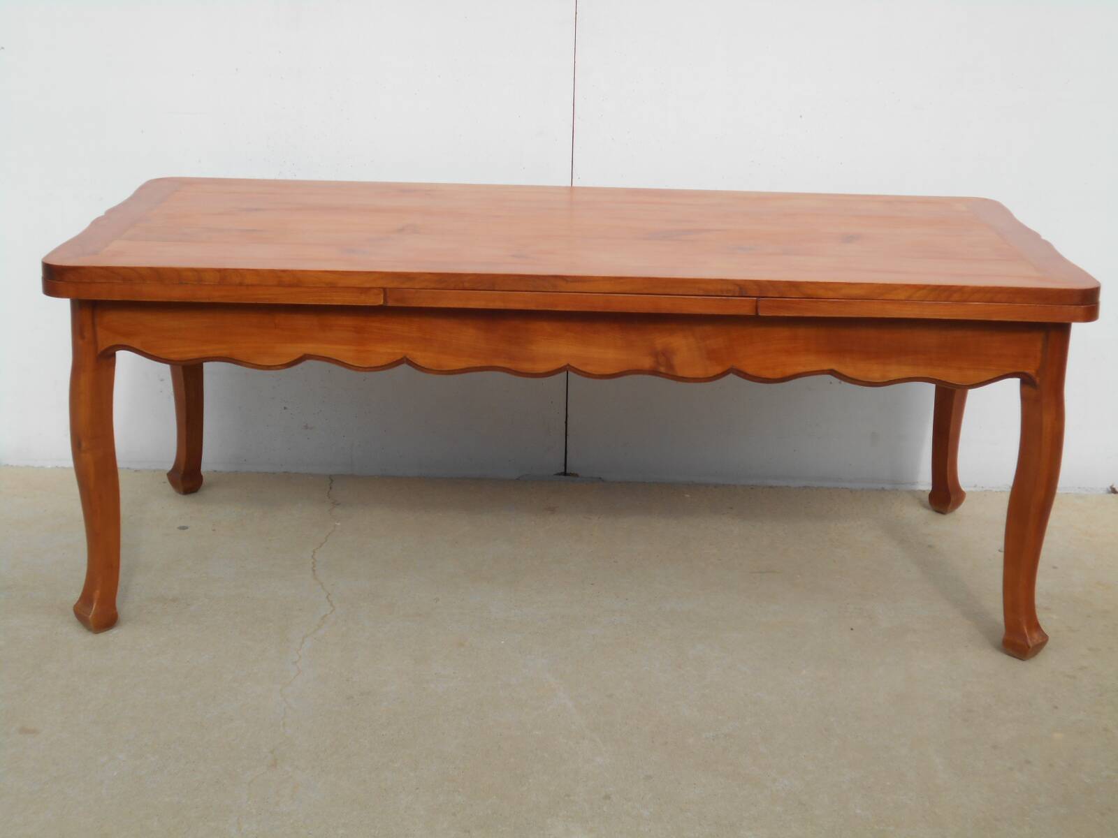 Large solid wood table with integrated extensions.