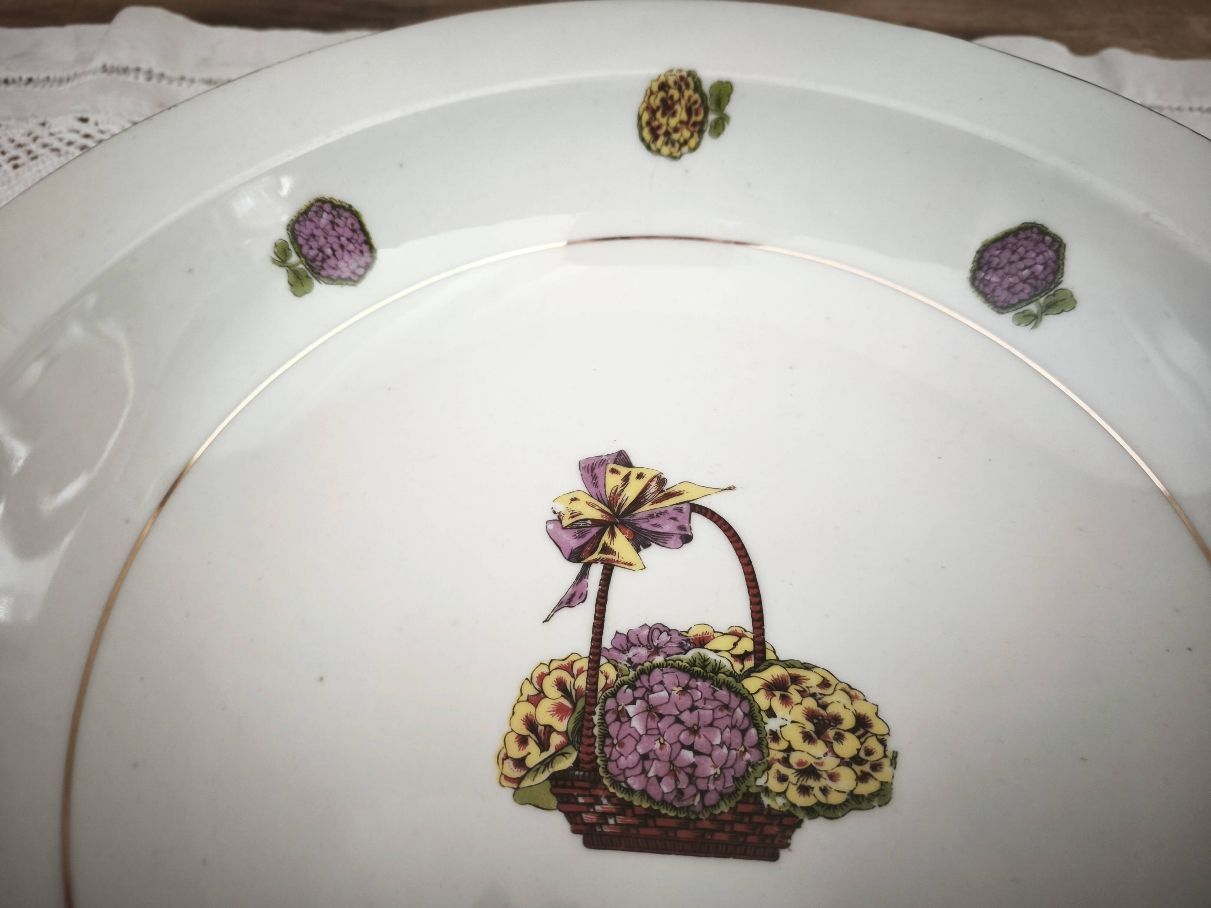 Shallow round plate in Limoges porcelain with a hydrangea basket design.