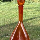 Orange bubbled glass bottle with curved body, circa 1970