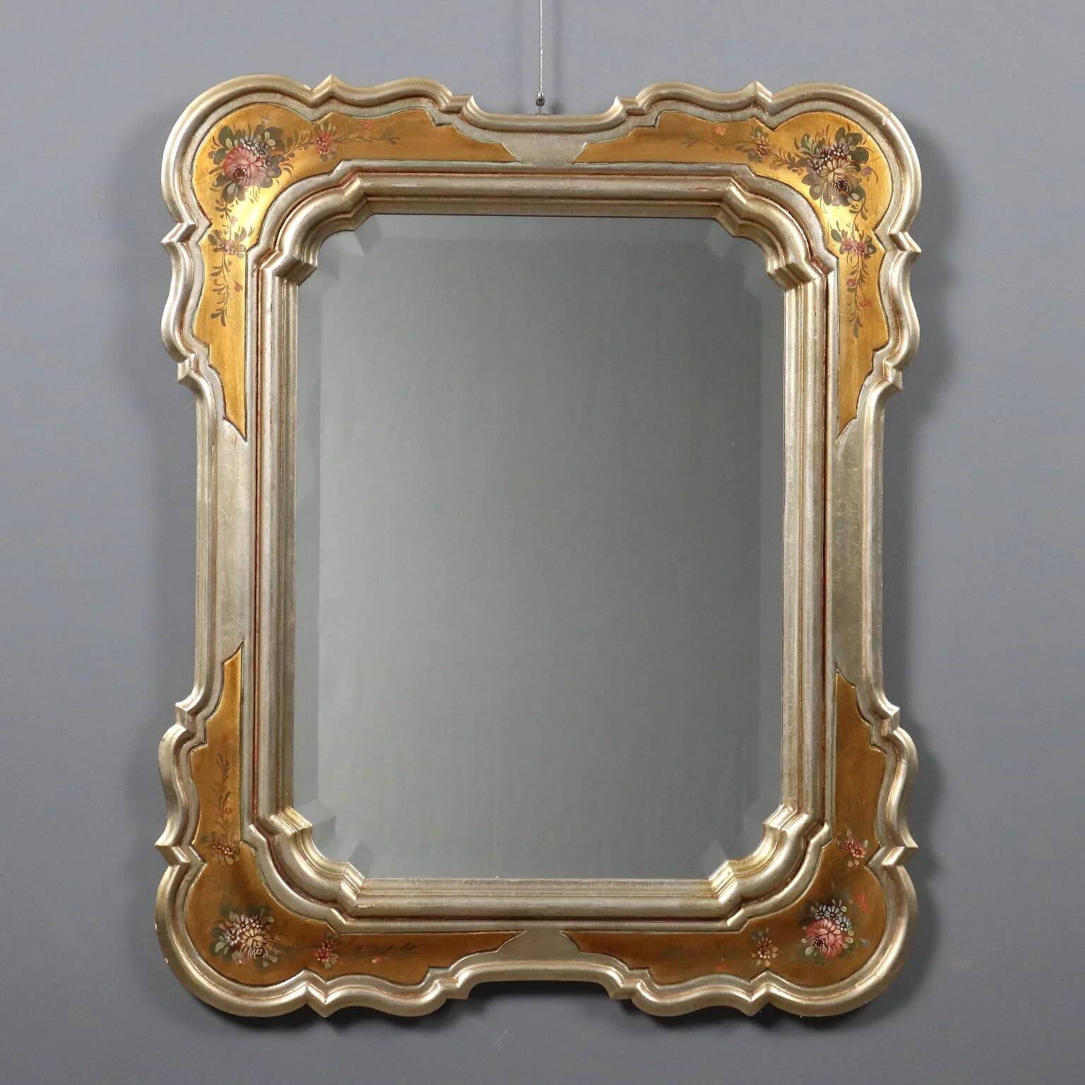 Antique mirror with a gilded frame and floral decorations, Italy, 20th century.