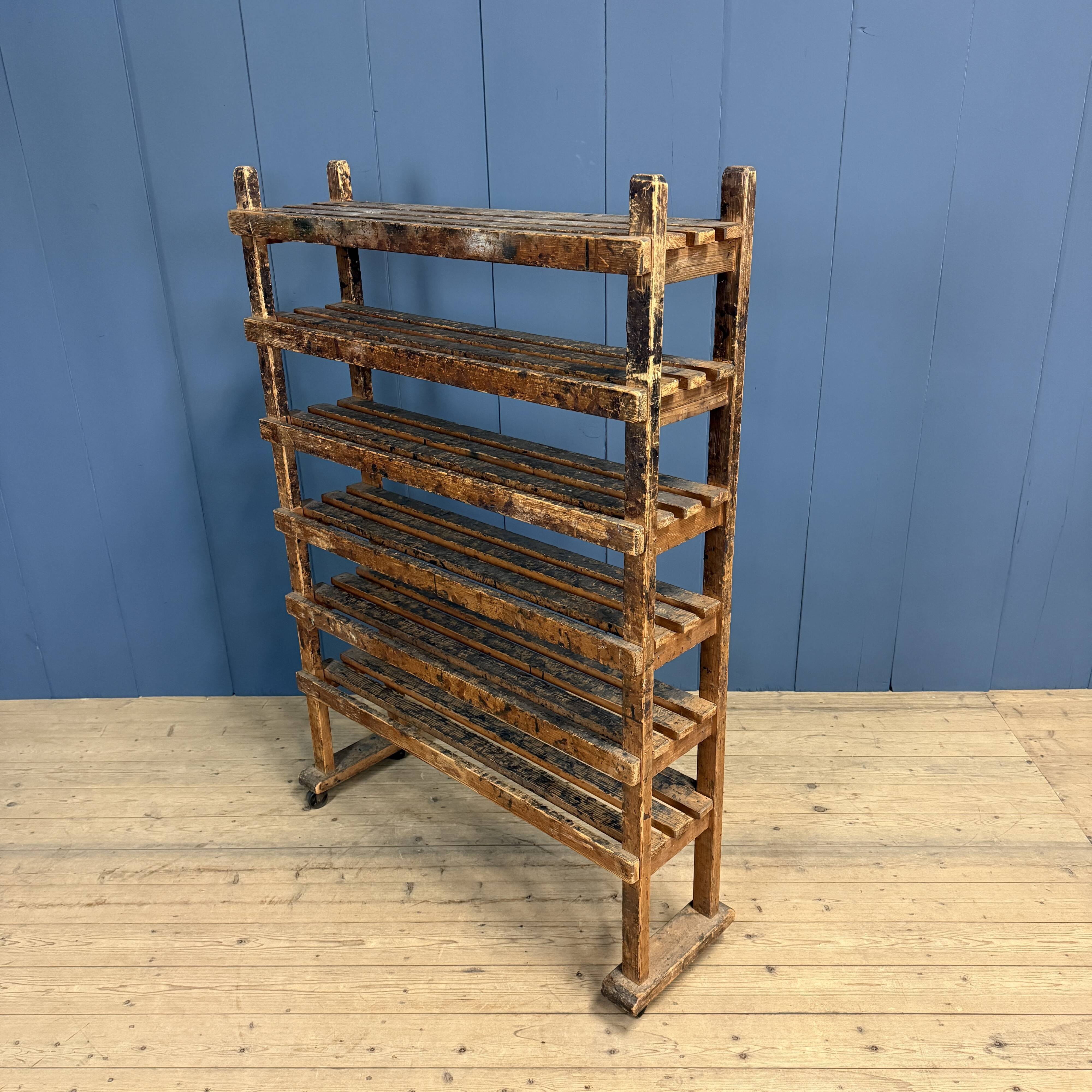 Old wooden workshop shelf with cast iron wheels.
