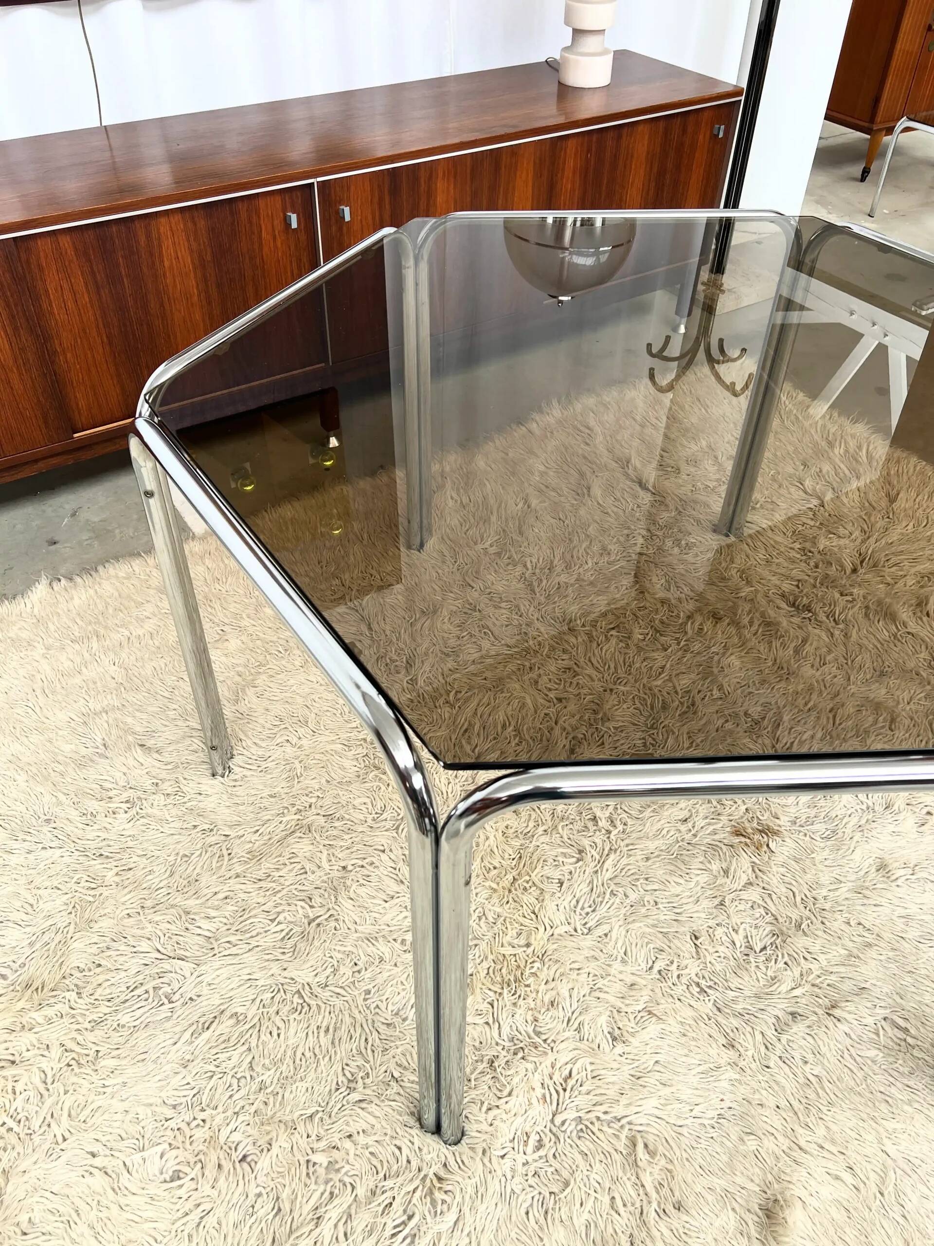 Vintage hexagonal table with smoked glass top and chrome metal structure.