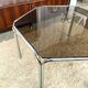 Vintage hexagonal table with smoked glass top and chrome metal structure.