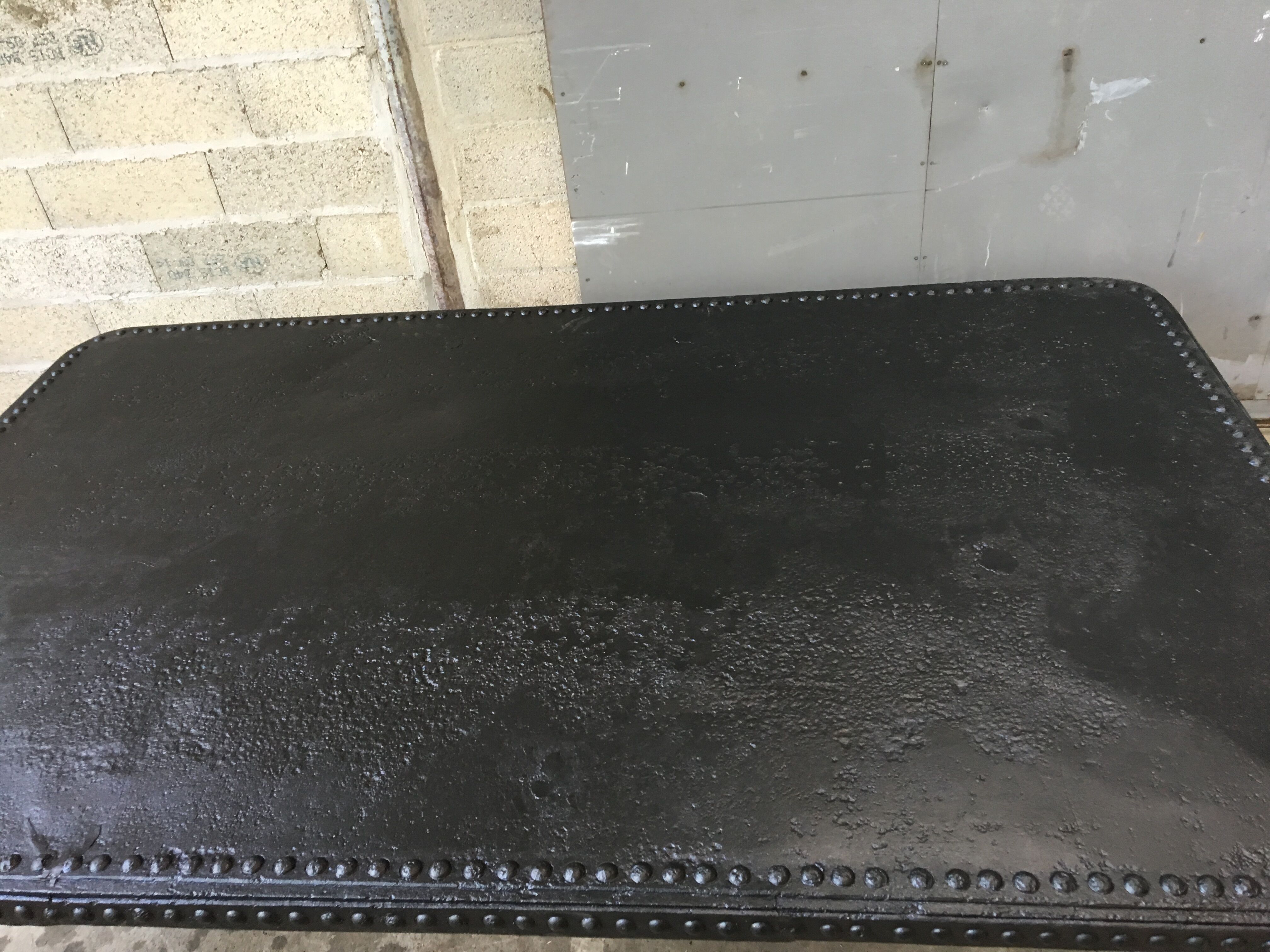 large industrial table in graphite black riveted metal