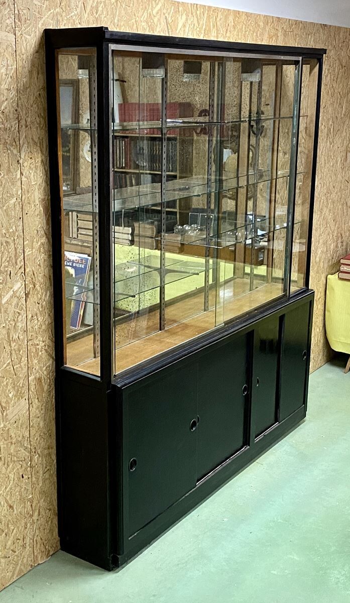 Store window with sliding doors in matte black patinated oak - 30s