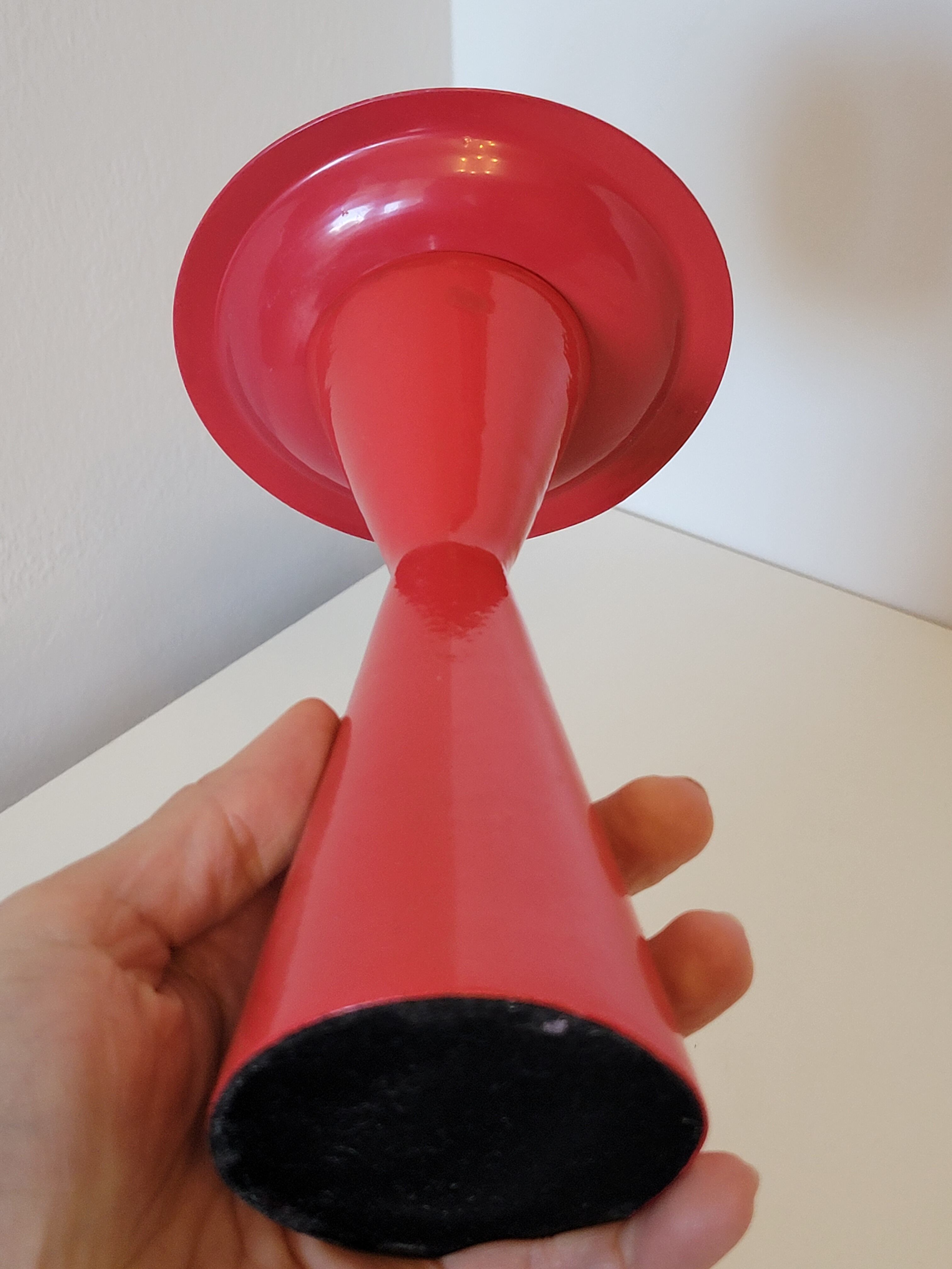 Vintage design candlestick in red metal in the shape of an hourglass