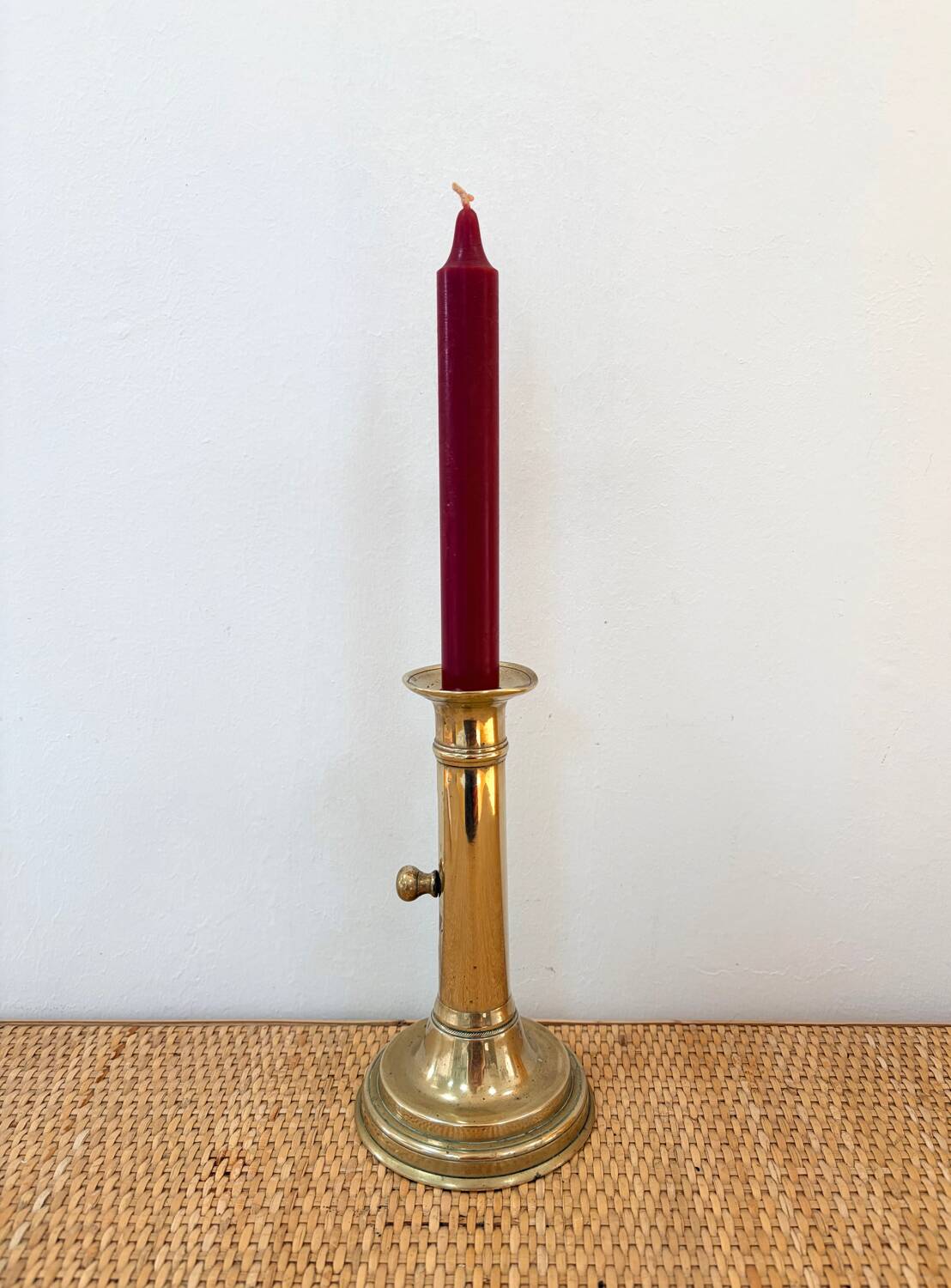 Old brass candlestick with push button.