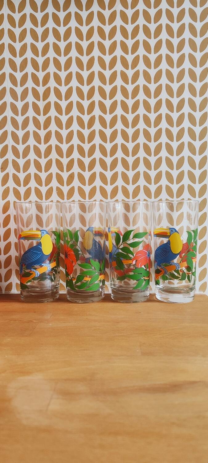 Vintage lemonade glasses with tropical parrot and flower patterns.
