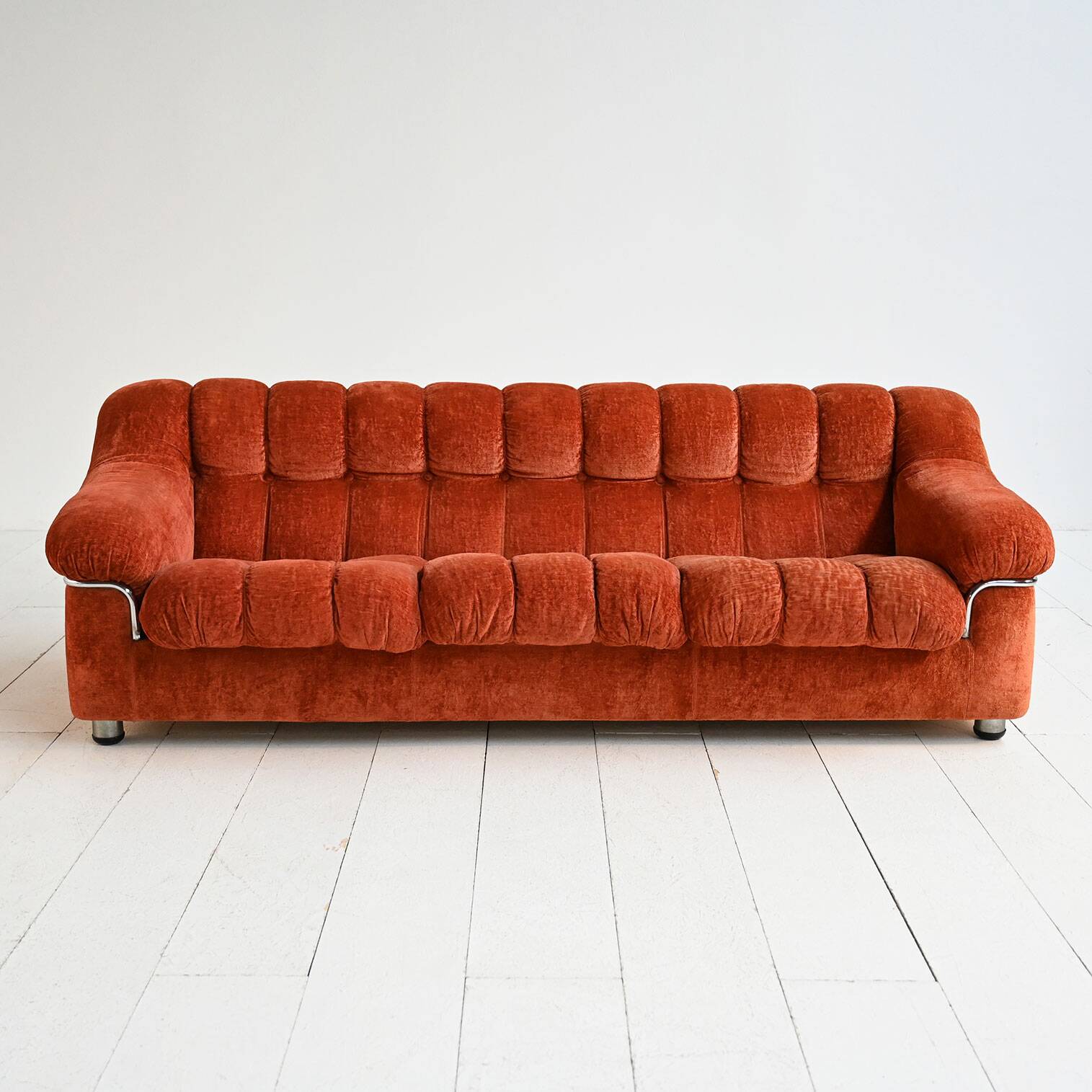 Vintage rust velvet sofa from the 1970s with metal details.