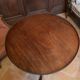 Foldable tripod side table in carved mahogany with brass trim.