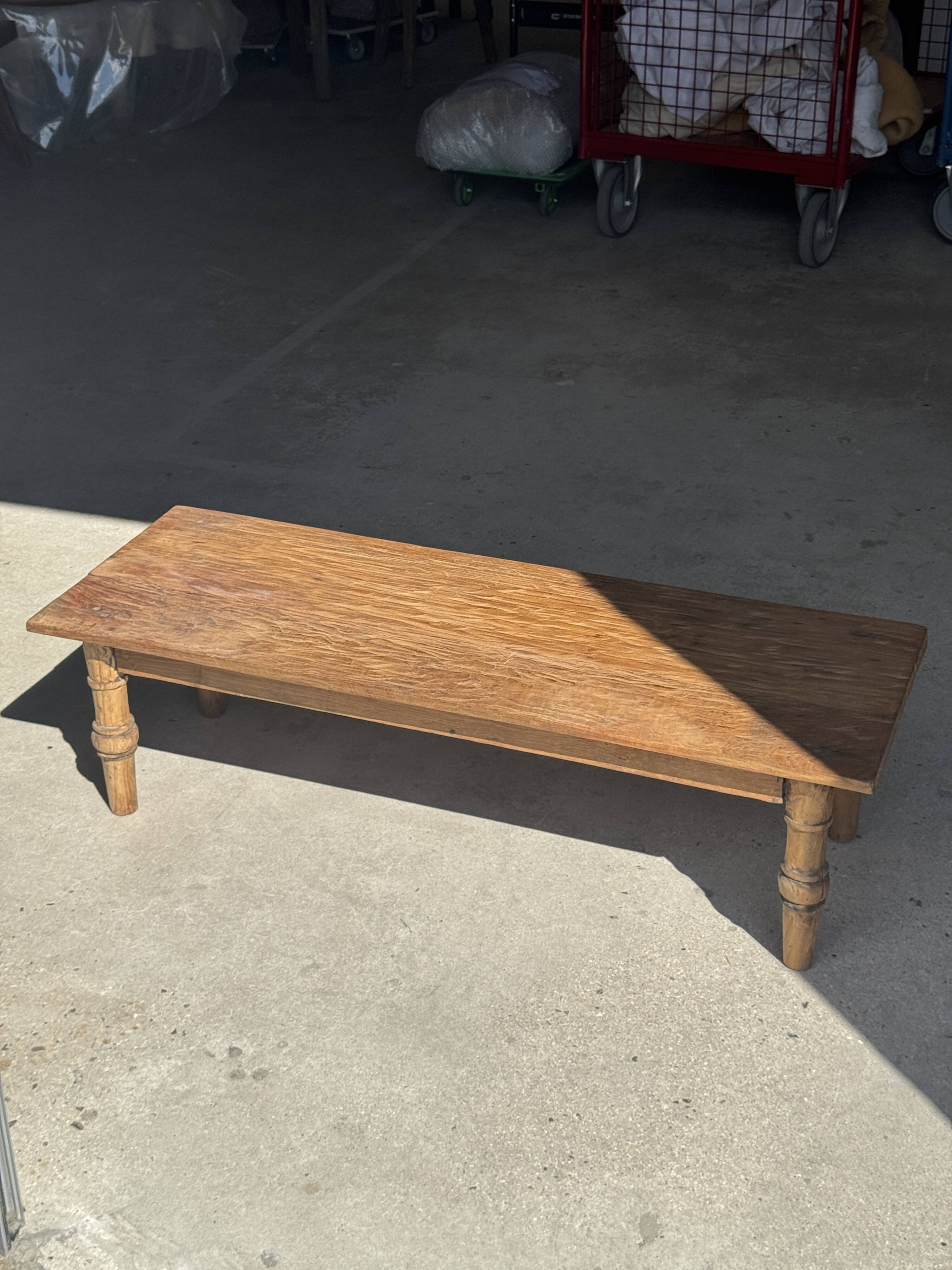 Brown Indonesian teak coffee table, with a border and cylindrical legs H40 L103.