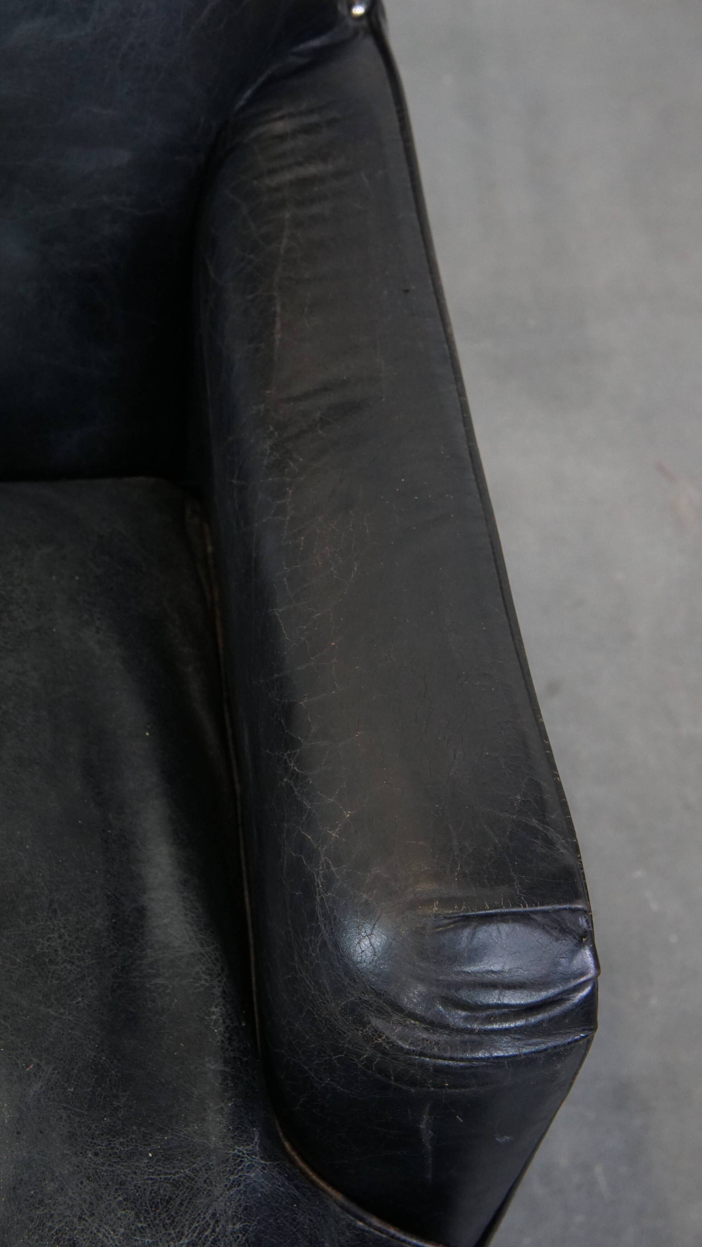 Armchair in black grained cowhide leather with a deep seat